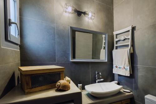 a bathroom with a sink and a toilet and a mirror at Kalimera & Apoplous boathouse in Klima