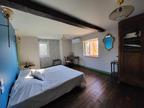 1 dormitorio con cama blanca y suelo de madera en Gîte PRAT NAOU - PYRENNEES ARIEGEOISES, en Taurignan-Vieux