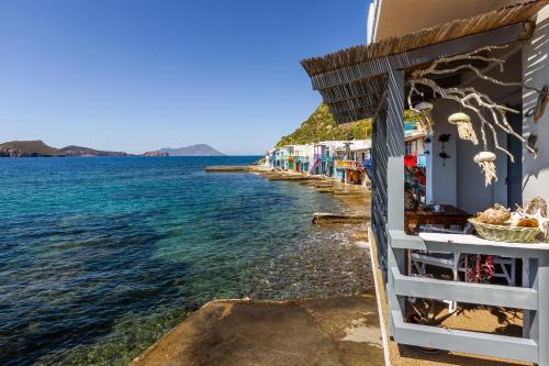 a row of houses on the shore of the water at Kalimera & Apoplous boathouse in Klima