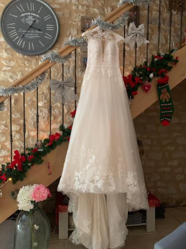 a wedding dress hanging on a staircase with a clock at Ecole de Mathuna de Marigny Brizay in Marigny-Brizay
