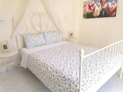 a bedroom with a white bed with a white bedspread at Akrogiali in Skala