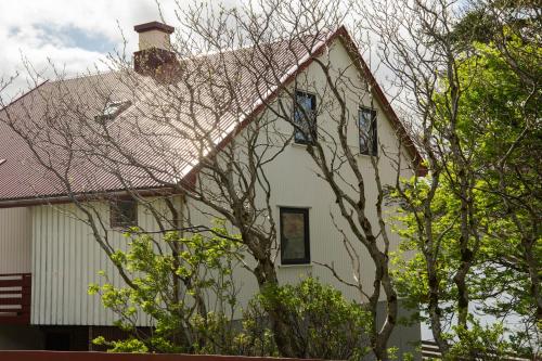 a white house with a red roof and trees at Holidayhouse by the sea in Selatrað