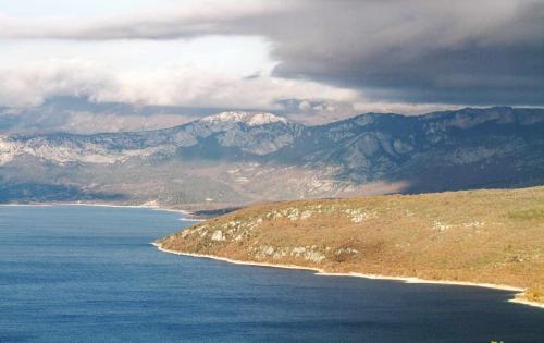a large body of water with mountains in the background at Appartement T2 "Altaïr" de l'observatoire in Bauduen