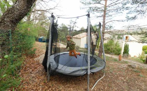 a small child sitting on a trampoline at Appartement T2 "Altaïr" de l'observatoire in Bauduen