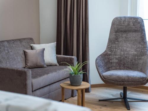 a living room with a couch and a chair at Platzhirsch Kufstein in Kufstein