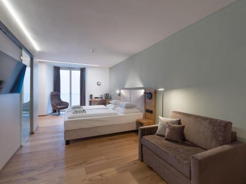 a bedroom with a bed and a couch at Platzhirsch Kufstein in Kufstein