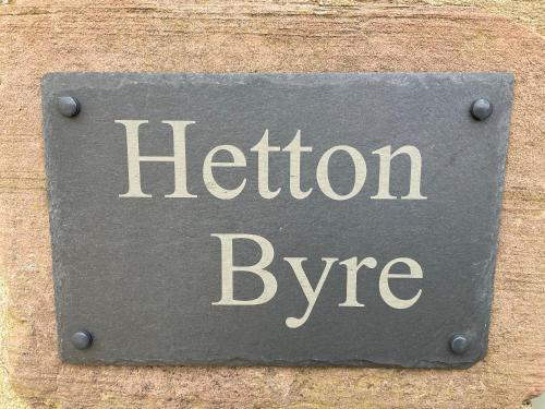 un letrero de metal que dice byte de helio en una pared en Hetton Byre en Lowick