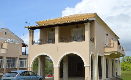 une maison avec une voiture garée devant elle dans l'établissement Homes near Golf The Elysian Beauty of Ermones, à Vátos