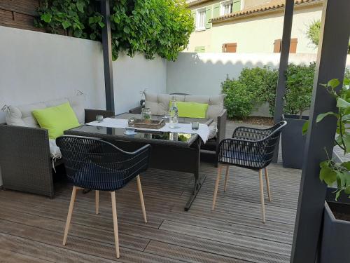 patio ze stołem i krzesłami na tarasie w obiekcie Maison chaleureuse et familiale w Carcassonne