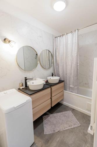 une salle de bain avec deux lavabos et deux miroirs dans l'établissement ✼ Jardin-Parking-Proche plage et calanque, à Marseille