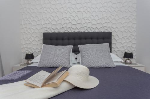 a bed with two books and two hats on it at Apartments Pera in Hvar