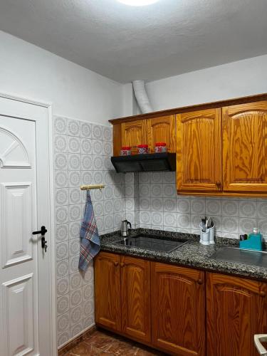 a kitchen with wooden cabinets and a sink at Casa Blanca in Alojera