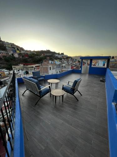 a balcony with chairs and tables and a view of a city at Casa Dos Fridas - Centro Guanajuato in Guanajuato