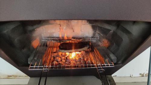 an oven with a food cooking in it at Appartement 5 personnes avec accès piscine in Thyle