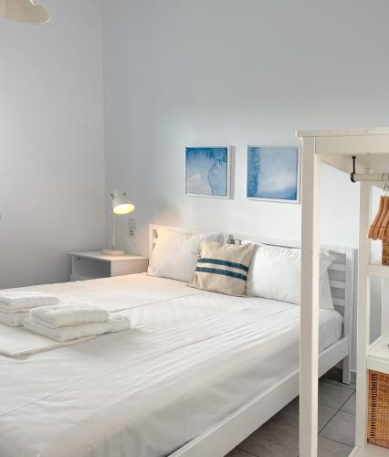 a white bed in a white bedroom with blue and white at Vanis House Sunset View Kythira in Kythira