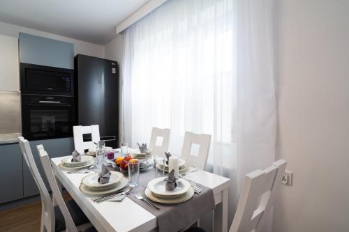 comedor con mesa blanca y sillas en Apartament Zielony Przylądek, en Brwinów