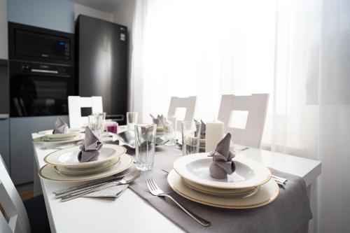 a dining room table with plates and napkins on it at Apartament Zielony Przylądek in Brwinów