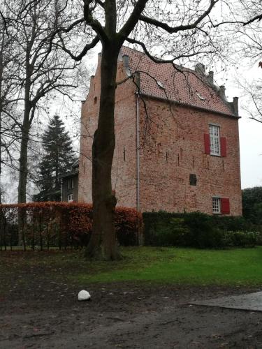 a large brick building with a tree in front of it at Ediths Haus in Rhauderfehn