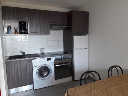une cuisine avec un lave-linge et un lave-linge dans l'établissement Bel Appartement en résidence avec Parking Privé, à Arvert