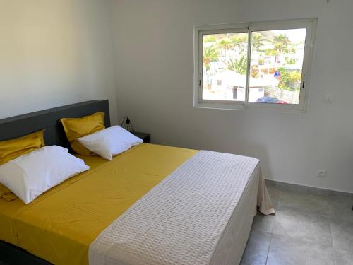 una camera da letto con un grande letto e una finestra di Maracuja 16, au centre d'Orient Bay, plage à 100m a Saint Martin
