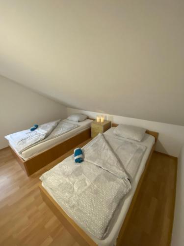 two twin beds in a room with wooden floors at Villa Enio in Bihać