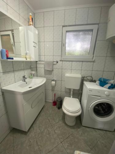 y baño con lavamanos y lavadora. en Villa Enio, en Bihać