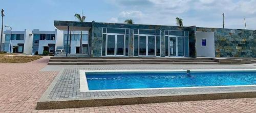 una casa con piscina frente a un edificio en CASA JUNTO AL MAR MARINA BAY-MIRADOR PUNTA BLANCA en Manta