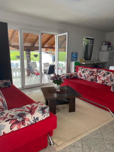 Una sala de estar con dos sofás rojos y una mesa. en Villa Enio, en Bihać