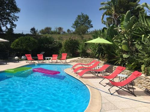 une piscine avec chaises et parasols dans l'établissement VILLA LES YUCCAS - Pool - Sea view, à Cagnes-sur-Mer