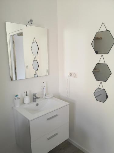 une salle de bain blanche avec un lavabo et un miroir dans l'établissement T3 avec salle de bain privative par chambre, à Agen