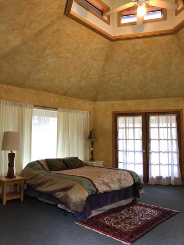China Bend Winery Bed and Breakfast في Kettle Falls: غرفة نوم بسرير كبير في غرفة بها نوافذ