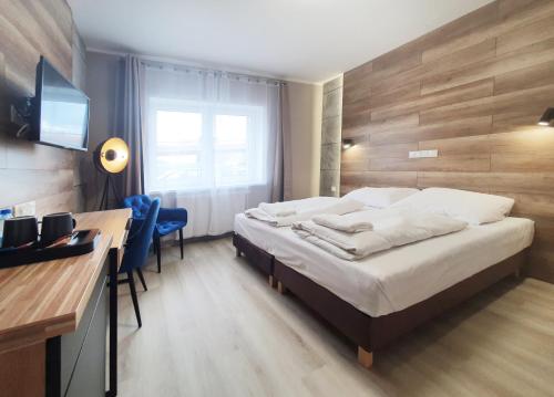 Habitación de hotel con cama y escritorio con ordenador en Kamienica Morska Gdynia, en Gdynia