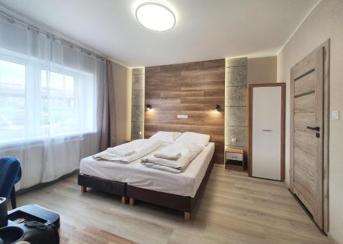 a bedroom with a bed with a wooden wall at Kamienica Morska Gdynia in Gdynia