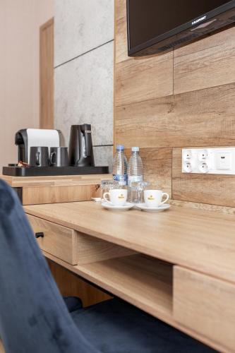 a table with two cups and water bottles on it at Kamienica Morska Gdynia in Gdynia