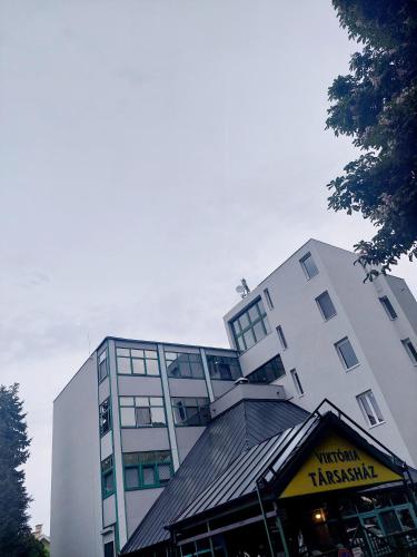 a tall white building with a restaurant in front of it at haJÓ Apartman in Keszthely