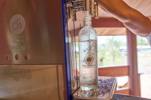 a bottle of water is hanging from a refrigerator at Hotel Boutique Frangipani in Brotas