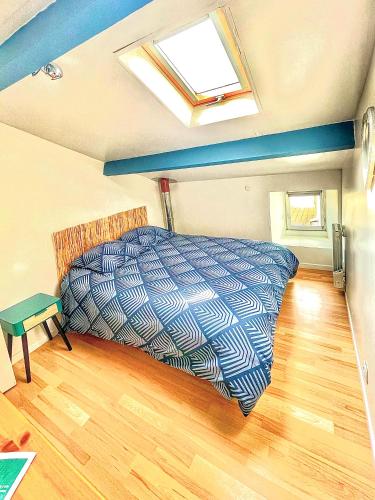 a bedroom with a bed in a room with a skylight at Ti Kaz Auberge in Saint-Just