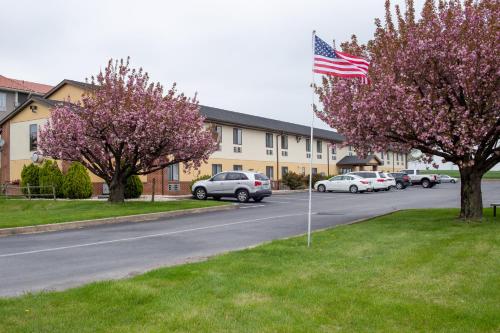 a american flag on a street with cars parked in a parking lot at Eastbrook Inn in Ronks