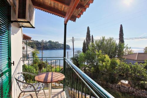a balcony with a table and chairs and a view of the water at Zoulis Eleni in Kalami