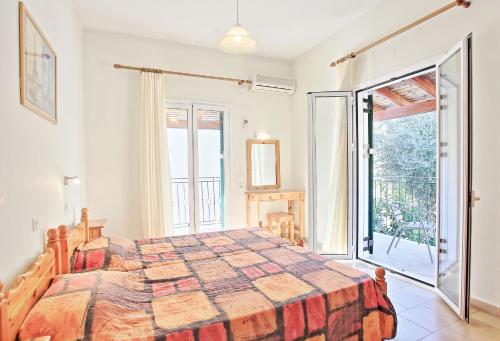 カラミにあるZoulis Eleniのベッドルーム1室(ベッド1台付)、スライド式ガラスドアが備わります。