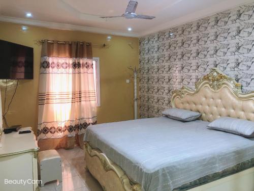 a bedroom with a king sized bed in a room at AwaMuuLamin MANNEH GUEST HOUSE in Abuko