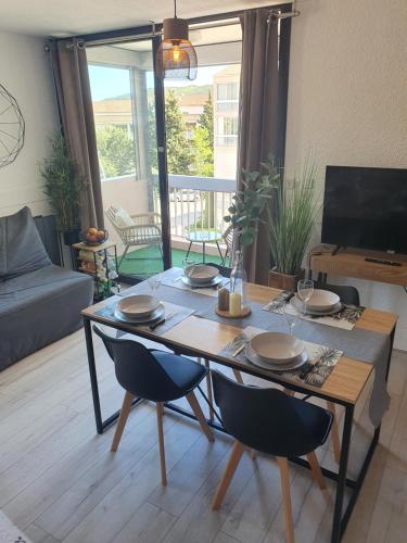 - une table à manger et des chaises dans le salon dans l'établissement L'exotique !, à Gréoux-les-Bains