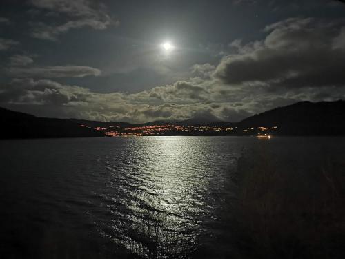 a full moon over a body of water at night at Bergen sunrise Apartment - self check in - Free Parking in Bergen