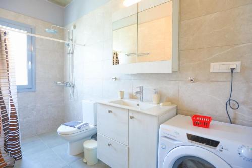 a bathroom with a washing machine and a washer at Villa Christina in Pouládes