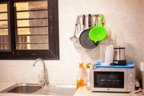 a kitchen counter with a sink and a microwave at Mouna in Dakar