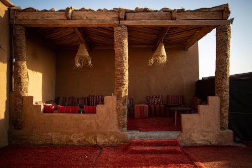 a room with chairs and tables in a building at Desert Luxury Camp in Mhamid
