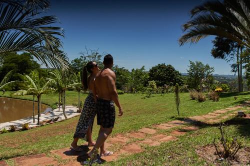 a man and a woman standing on a path at Hotel Boutique Frangipani in Brotas