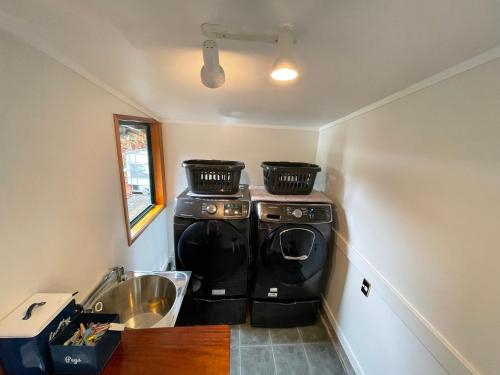a kitchen with two washing machines and a sink at Tikitere Lodge, Rotorua in Rotorua