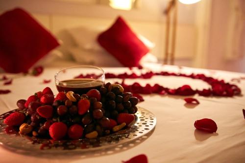 a plate of fruit on a table with a drink at Hotel Boutique Frangipani in Brotas