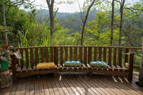 a wooden bench sitting on a deck with pillows at Chalets HUITACA in Choachí